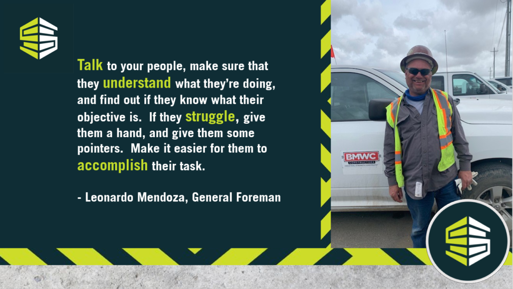 General foreman standing in front of truck in work construction gear. Talk Understand Struggle Accomplish in bold. Leonardo Mendoza 